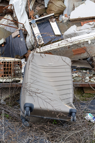 Картината върху платно A heartbreaking view of a damaged suitcase among the rubble of destroyed buildings