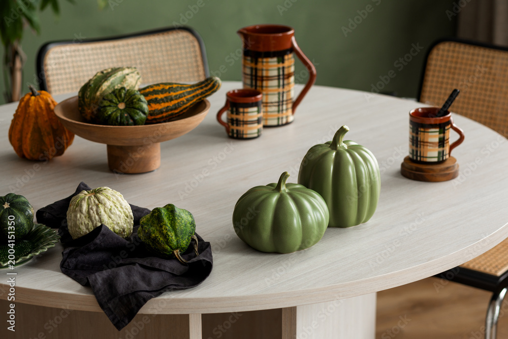 Naklejka premium Autumn harvest decoration with pumpkins and gourds on a stylish table, perfect for seasonal inspiration and comfortable home aesthetics