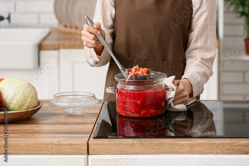 Young woman with ladle full...