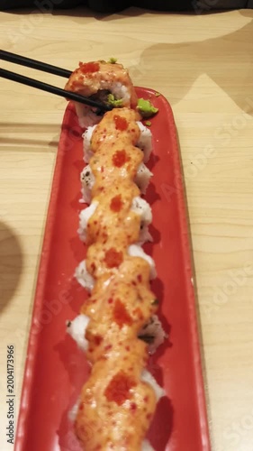 Vertical sushi roll video on red plate, Asian food close up