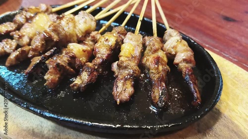 Goat grilled satay skewers on hot plate, Indonesian street food close up