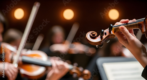 A close-up shot of a person playing the violin with a band playing in the background.