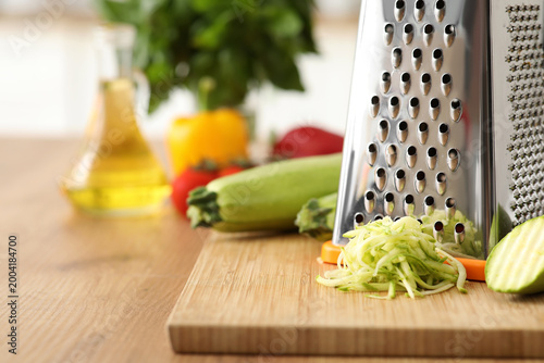 Grater with zucchini on tab...