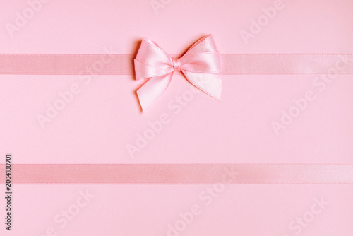 Pink satin ribbon bow on horizontal ribbons with copy space