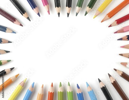 Colorful wooden pencils arranged in a circle frame on a white background