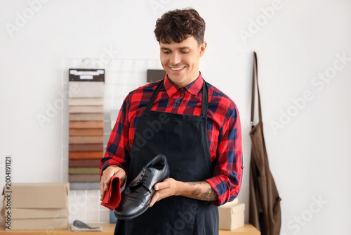 Male shoemaker cleaning sho...