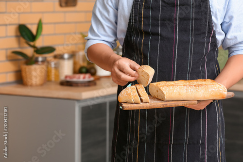 Young man with fresh bread ...