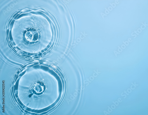 Two water ripples with concentric circles on blue background.