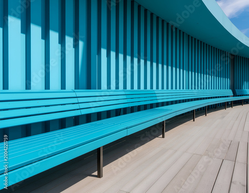 Curved turquoise benches beneath modern ribbed canopy.