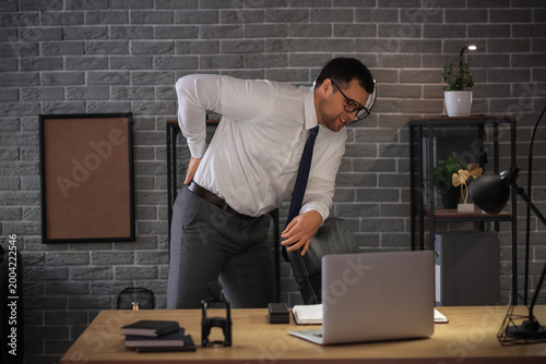 Young businessman suffering...