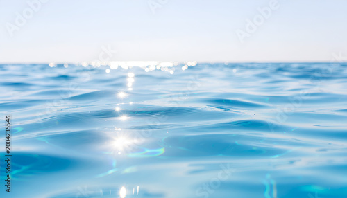 Sparkling blue ocean surface under bright sky.