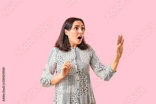 Quadro su tela Shocked young woman on pink background