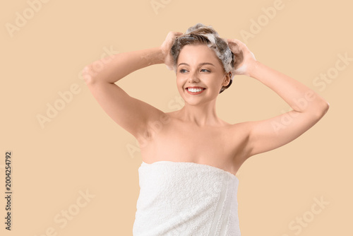Young woman washing hair on...