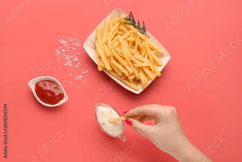 Woman dipping french fries ...
