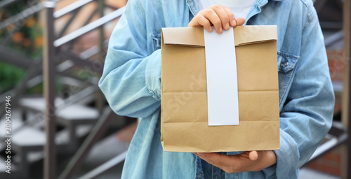 Woman with paper bag outdoo...