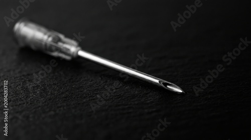 Hypodermic Needle Precision: A macro shot of a hypodermic needle displaying precise engineering, highlighting sharpness on black backdrop creating visual intrigue.