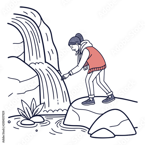 A woman in a red vest and sneakers standing on a rock near a waterfall