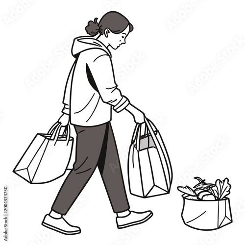 A woman walking with grocery bags in her hands and another bag on the ground beside her