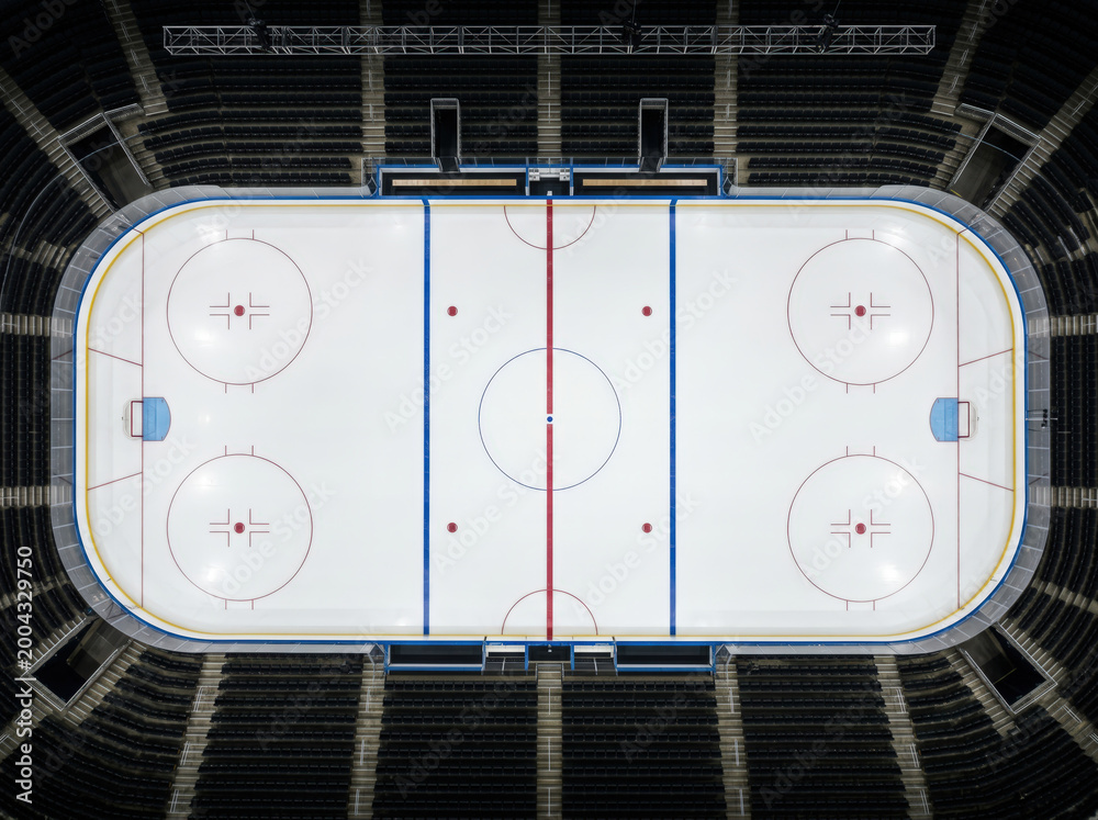 Obraz premium Top view of an empty hockey rink with red and blue markings and no signs or logos on the ice.