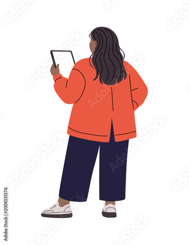 Woman stands, holding tablet, dressed in orange top and dark pants. Back view shows her focused, engaged with digital content. Simple lines, soft colors, modern lifestyle illustration