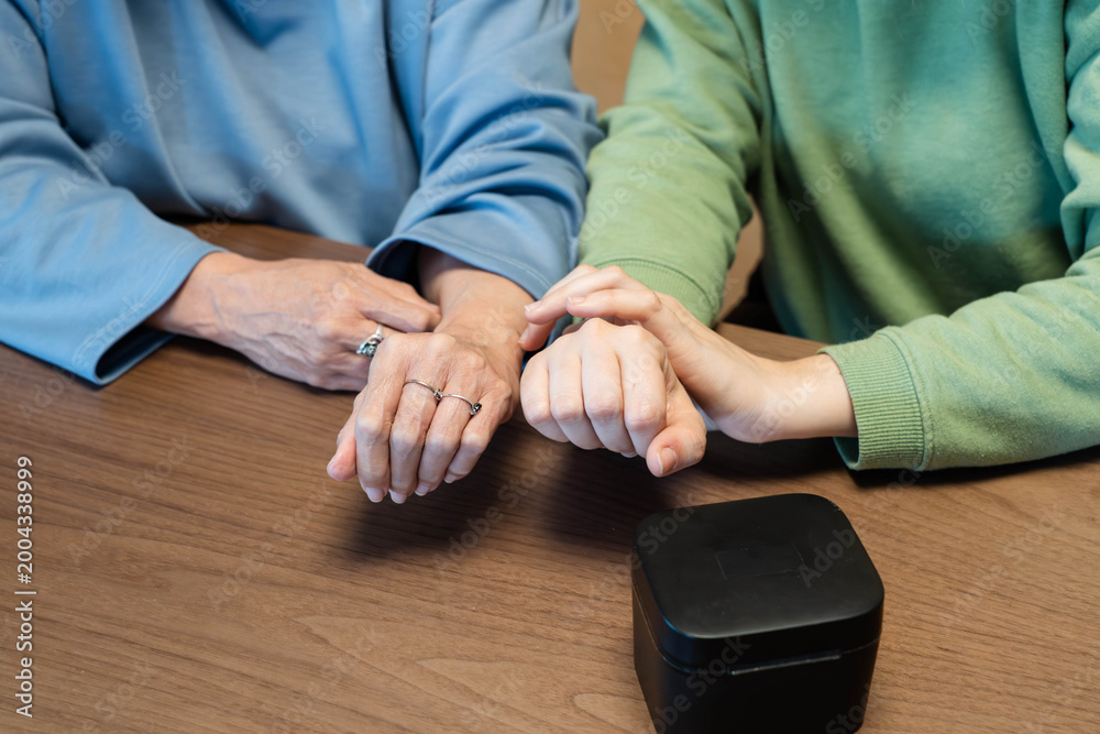 Fototapeta premium Young person comforting senior with gentle touch