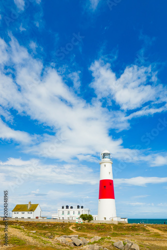 Coastal landscape highlighting the vast sky above historic lighthouse facilities (Portland, England, United Kingdom)