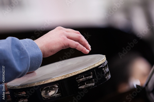 Close-up of a musician's hand playing a tambourine