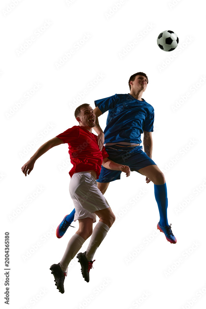 Fototapeta premium Soccer aerial duel with blue forward rising above red defender on white background. Concept of match intensity, header challenge, sports advertising and tournament promo.