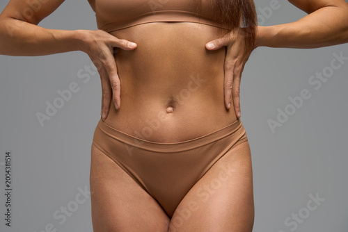 Close-up of woman with hands on waist showing muscle soreness and body awareness