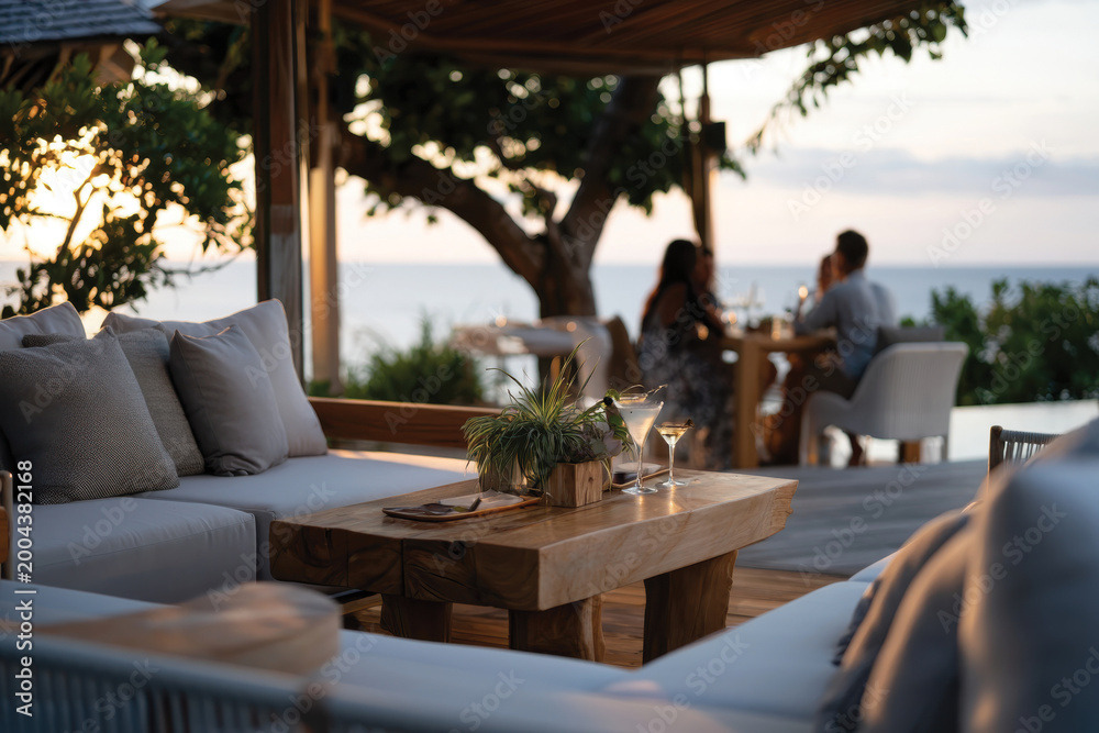Fototapeta premium An elegant outdoor dining setup featuring beautifully arranged tables and stunning coastal views, creating a serene atmosphere for memorable meals with loved ones.