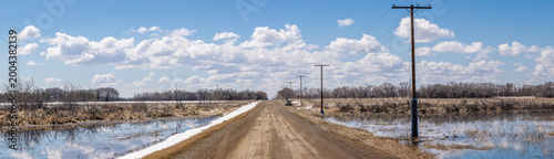 Panoramic view of a gravel grid road in rural Saskatchewan in early Spring during the last phase of snow melt.