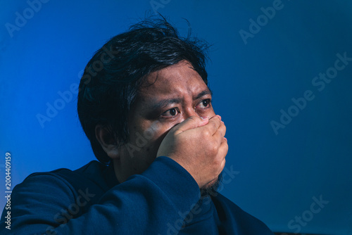 Fotografija A shocked adult male subject completely covers his mouth with his hand while sta