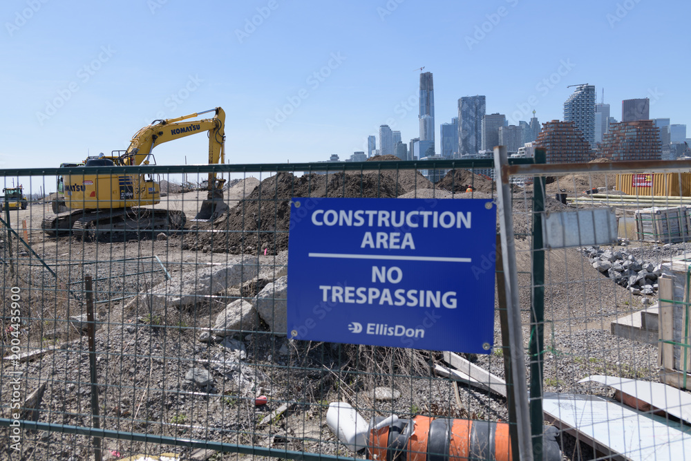 Fototapeta premium blue EllisDon construction area sign at Port Lands, with skyline of downtown Toronto