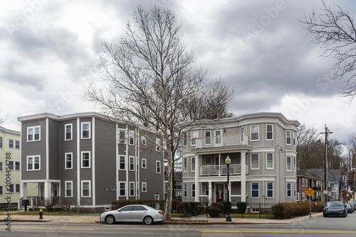 Residential street scene featuring modern and traditional multifamily homes under overcast sky in the Brighton neighborhood of Boston, Massachusetts