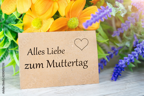 Foto Liebevoller Muttertagsgruß auf einer Karte, umgeben von bunten Frühlingsblumen (