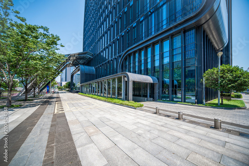 Sleek Modern Skyscraper Surrounded by Lush Greenery and Urban Walkways