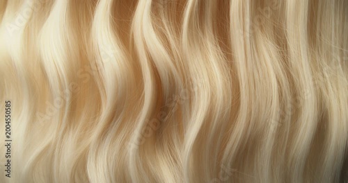 Ultra slow motion shot of blonde hair flowing in smooth, elegant waves, forming natural curves and motion. Captured at 1000 fps, revealing fine texture, shine, and fluid cinematic movement.