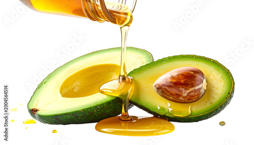 Avocado halves with golden liquid pouring, showcasing food freshness on a black background