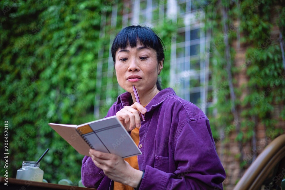 Fototapeta premium Creative woman working with notebook in nature