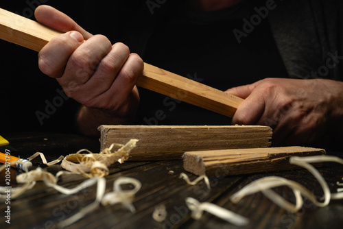 Tableau sur toile A person holds a piece of wood tightly while working on it in a workshop