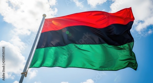 The pan african flag waving against a cloudy sky
