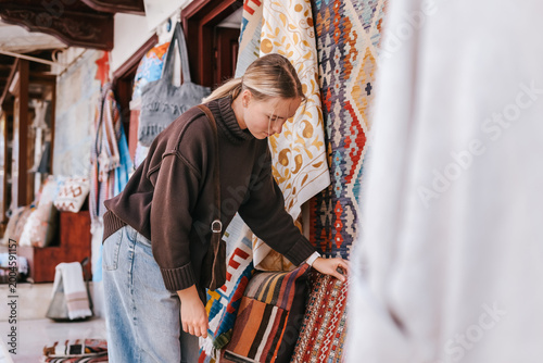 Foto Female traveler shopping at a local market, browsing handmade goods and souvenirs, authentic travel experience, local culture, small business and destination shopping concept