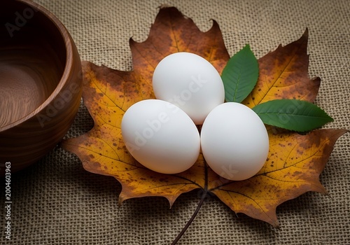 White eggs and green leafy vegetable on textured orange background, with cat textured surface