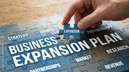 Business expansion plan puzzle with strategy growth market partnerships research and revenue concepts hand placing final piece symbolizing success and development