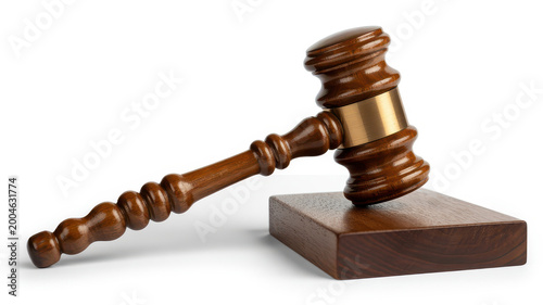 Wooden judge gavel with a brass band resting on a wooden sound block on a white background