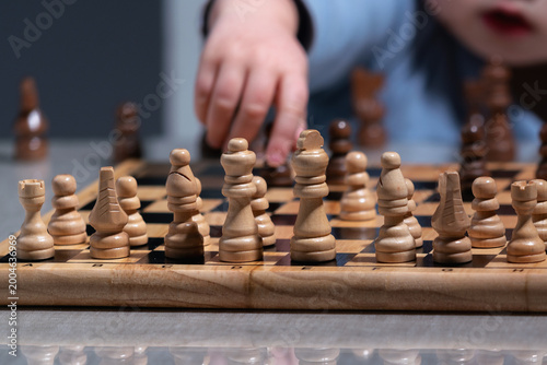 Photography Future grandmaster concept, toddler exploring chess pieces with curiosity and fo