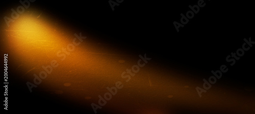 Fotografie Abstract golden light beam with grunge texture on black background, cinematic spotlight effect, film grain and scratches, dramatic lighting