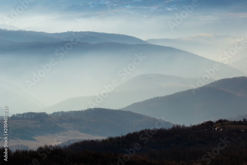 Foto Layered mountain landscape with mist and soft light creating atmospheric depth