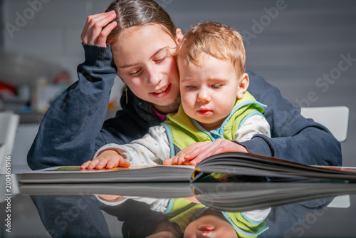 Children reading together, older sibling guiding younger, concept of support and learning