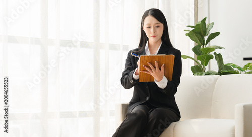Bild auf Leinwand Focused in the Office: An attractive businesswoman absorbed in her tablet in a minimalist office environment